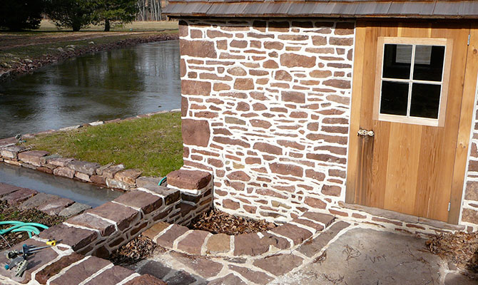 Detail of stone springhouse with ridge pointing
